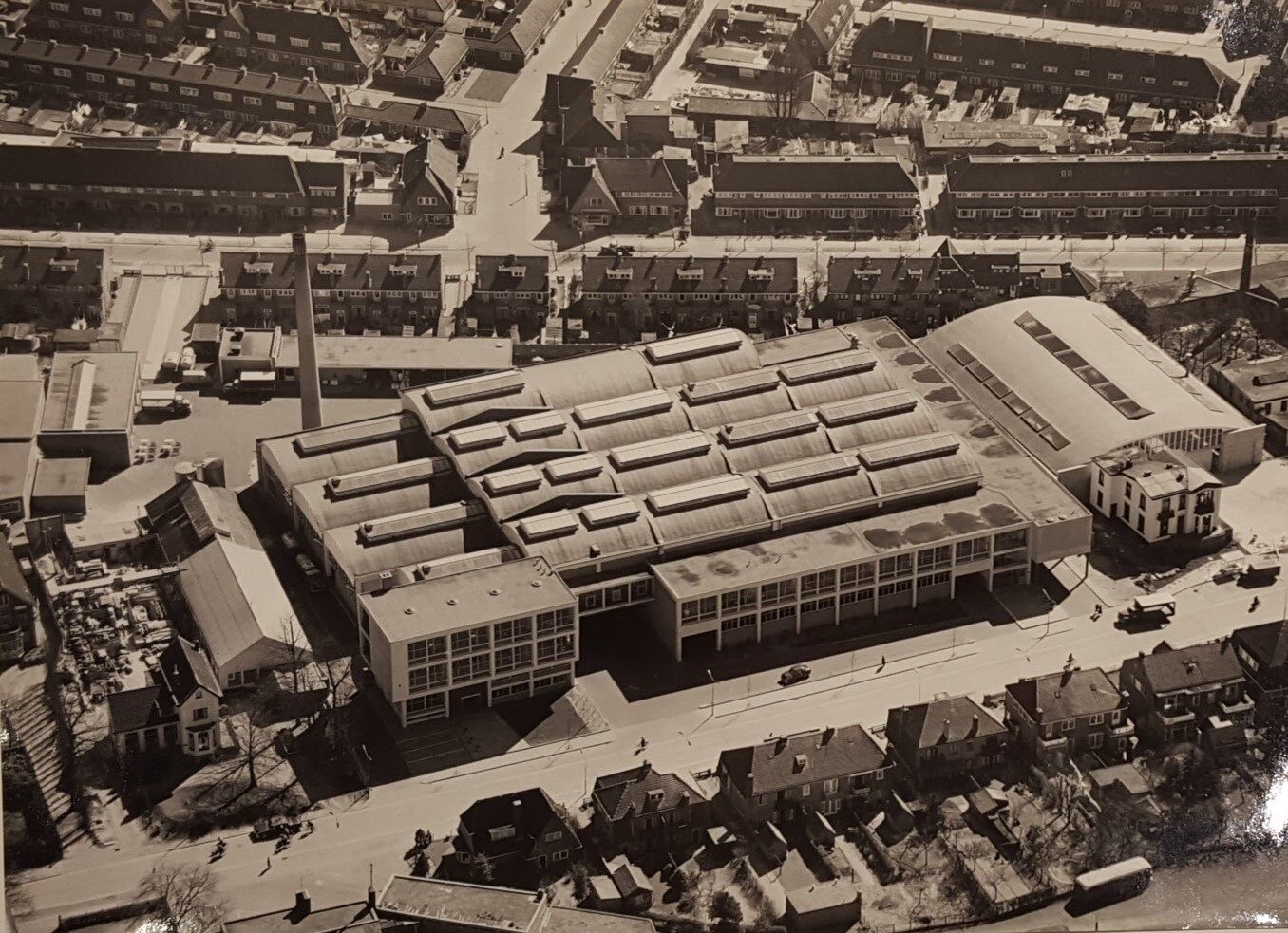 Luchtfoto van de Melkfabriek aan de Larenseweg in Hilversum, 1957, met de karakteristieke schaaldaken